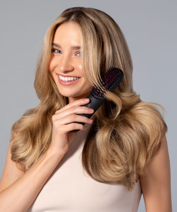 a woman holding a hair brush in her hand