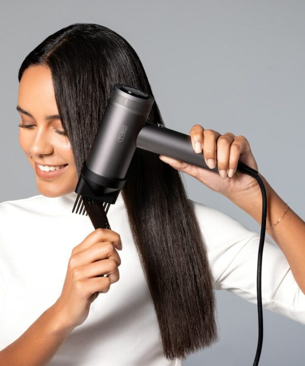 a woman blow drying her hair with a hair dryer