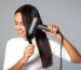 a woman blow drying her hair with a hair dryer